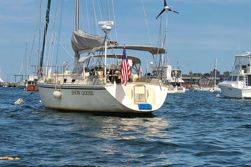 Slide: The Image of 1994 Caliber Cutter Rig sailboat "Snow Goose" anchored in a marina with American flag. - 2