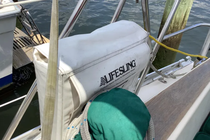 Slide: The Image of Lifesling on 1994 Caliber Cutter Rig sailboat, docked by wooden pier. - 27