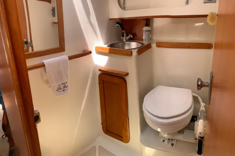 Slide: The Image of Compact bathroom in a 1994 Caliber Cutter Rig sailboat, featuring a toilet and sink. - 35