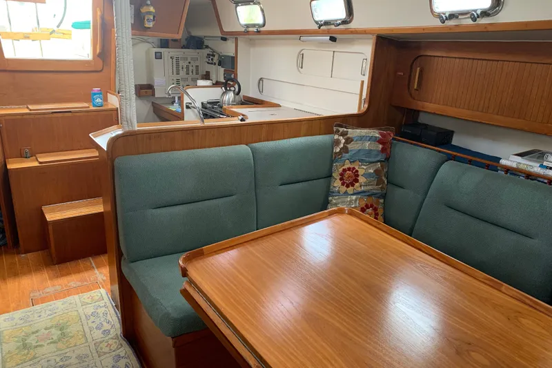 Slide: The Image of Cozy interior of 1994 Caliber Cutter Rig sailboat with wooden dining area and green seating. - 41