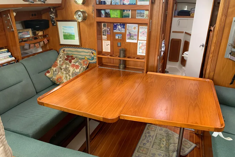 Slide: The Image of Cozy interior of a 1994 Caliber Cutter Rig sailboat with wooden table and seating. - 45