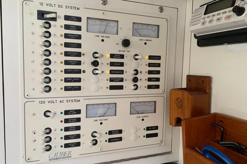Slide: The Image of Electrical control panel on a 1994 Caliber Cutter Rig yacht, featuring 12V DC and 120V AC systems. - 48