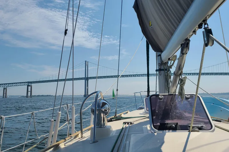 Slide: The Image of Sailing under a bridge on a 1994 Caliber Cutter Rig sailboat, clear skies above. - 6