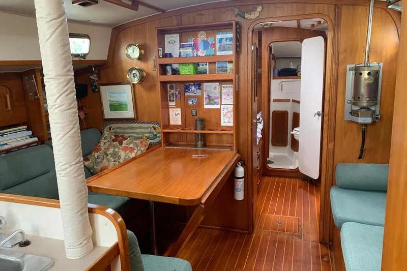 Slide: The Image of Interior of 1994 Caliber Cutter Rig sailboat with wooden furnishings and cozy seating area. - 67
