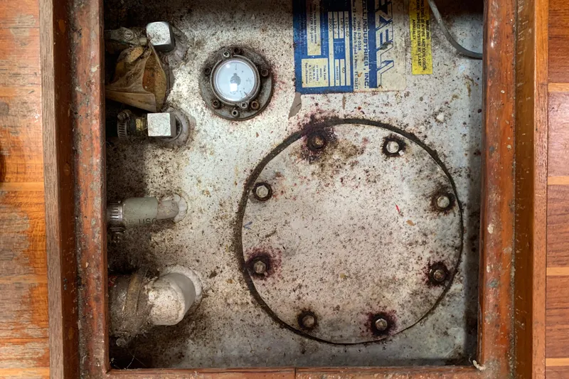 Slide: The Image of 1994 Caliber Cutter Rig engine compartment with gauge and pipes, showing wear and rust. - 68