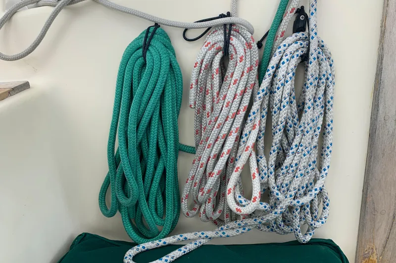 Slide: The Image of Coiled ropes on a 1994 Caliber Cutter Rig sailboat, featuring green and patterned designs. - 80
