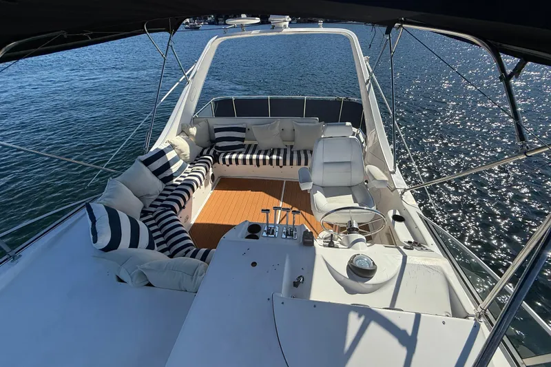 Slide: The Image of 1997 Bayliner 3988 Command Bridge Motoryacht with striped seating on sunny water. - 11