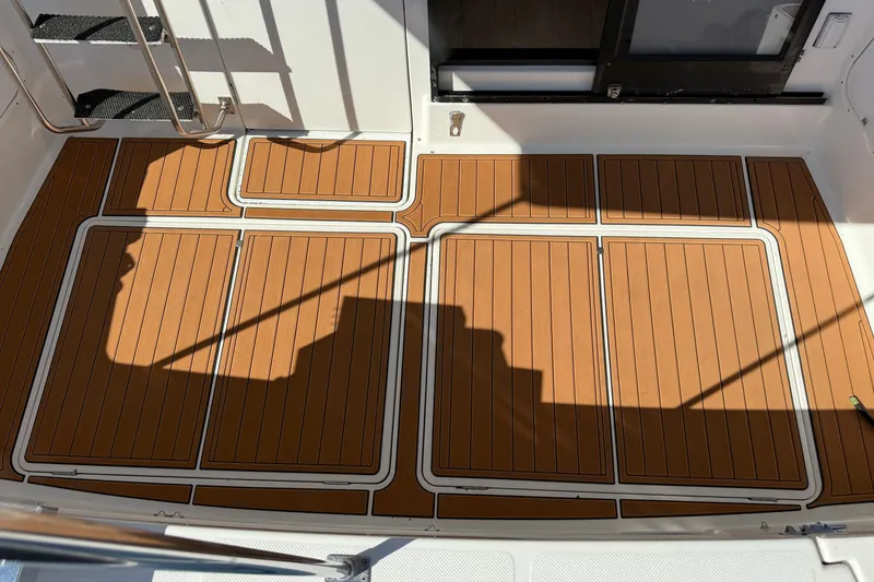 Slide: The Image of 1997 Bayliner 3988 Command Bridge Motoryacht deck with teak-style flooring and stainless steel railings. - 13