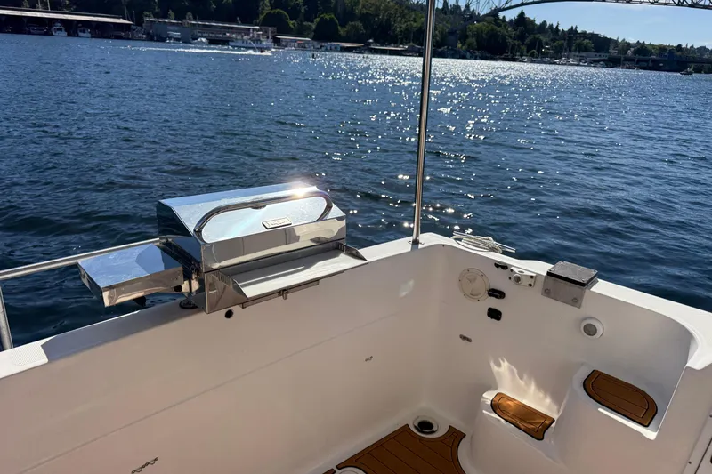 Slide: The Image of 1997 Bayliner 3988 Command Bridge Motoryacht deck with grill, overlooking serene waters. - 14