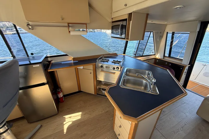 Slide: The Image of Interior of 1997 Bayliner 3988 Command Bridge Motoryacht with kitchen and scenic water view. - 19