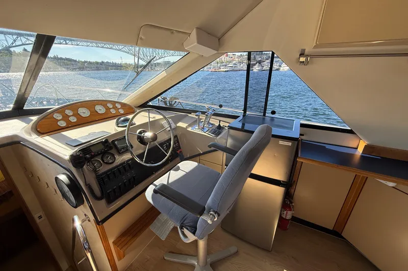 Slide: The Image of 1997 Bayliner 3988 Command Bridge Motoryacht helm with steering wheel, controls, and scenic water view. - 20