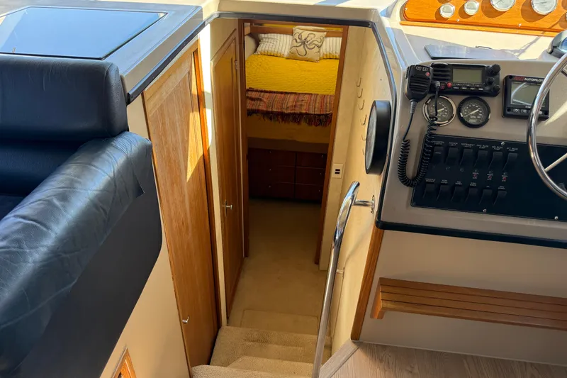 Slide: The Image of 1997 Bayliner 3988 Command Bridge Motoryacht interior with helm, stairs, and cozy cabin view. - 24