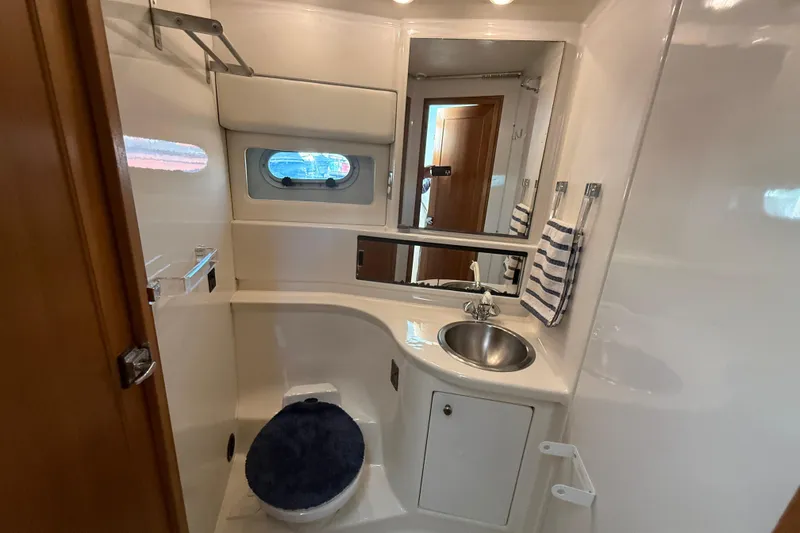 Slide: The Image of Bathroom interior of 1997 Bayliner 3988 Command Bridge Motoryacht, featuring sink and porthole window. - 31