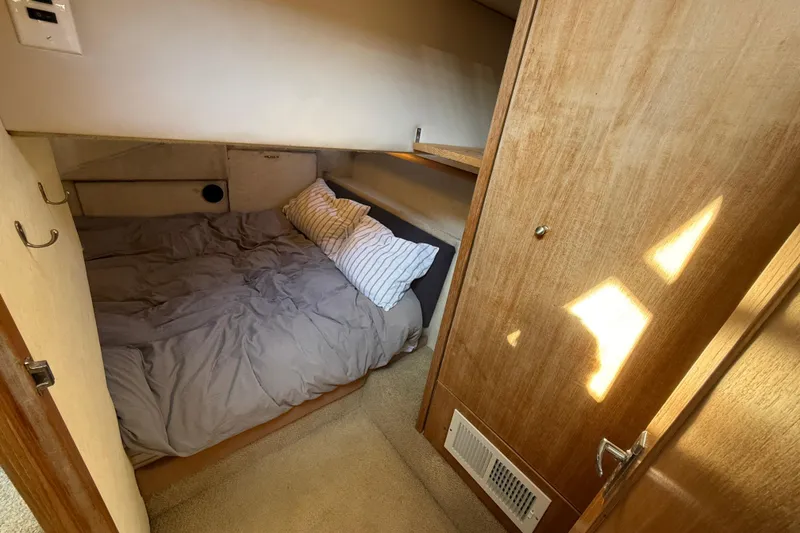 Slide: The Image of Cozy cabin interior of 1997 Bayliner 3988 Command Bridge Motoryacht with bed and wooden accents. - 32