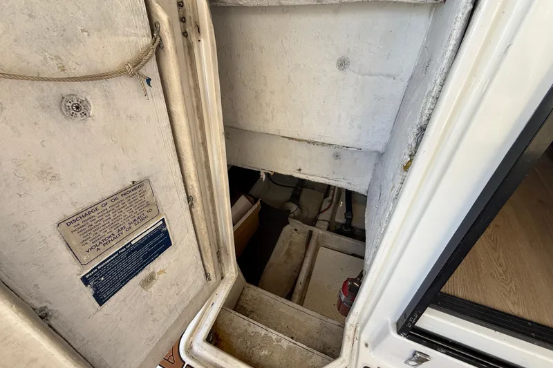 Slide: The Image of 1997 Bayliner 3988 Command Bridge Motoryacht engine room access with safety notice. - 34