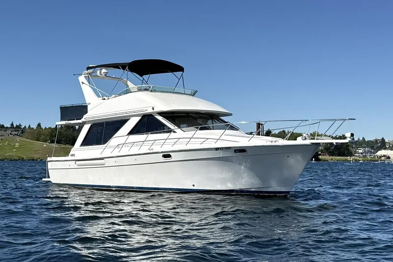 Slide: The Image of 1997 Bayliner 3988 Command Bridge Motoryacht on calm water under clear blue sky. - 6