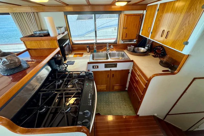 Slide: The Image of 1958 Blanchard Pilothouse kitchen with wooden cabinets, stove, and dual sink. - 19