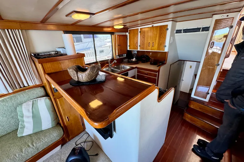 Slide: The Image of 1958 Blanchard Pilothouse interior with wooden cabinetry, cozy seating, and nautical decor. - 20