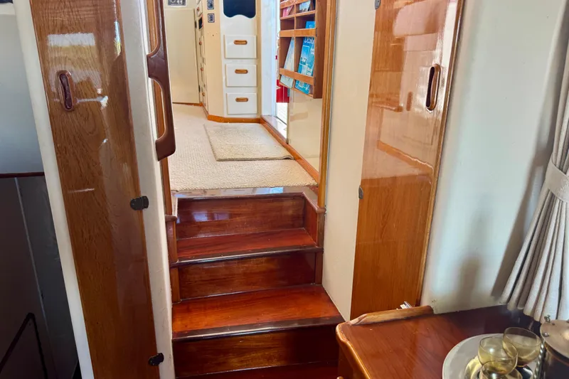 Slide: The Image of Interior of a 1958 Blanchard Pilothouse boat with polished wood and carpeted steps. - 23