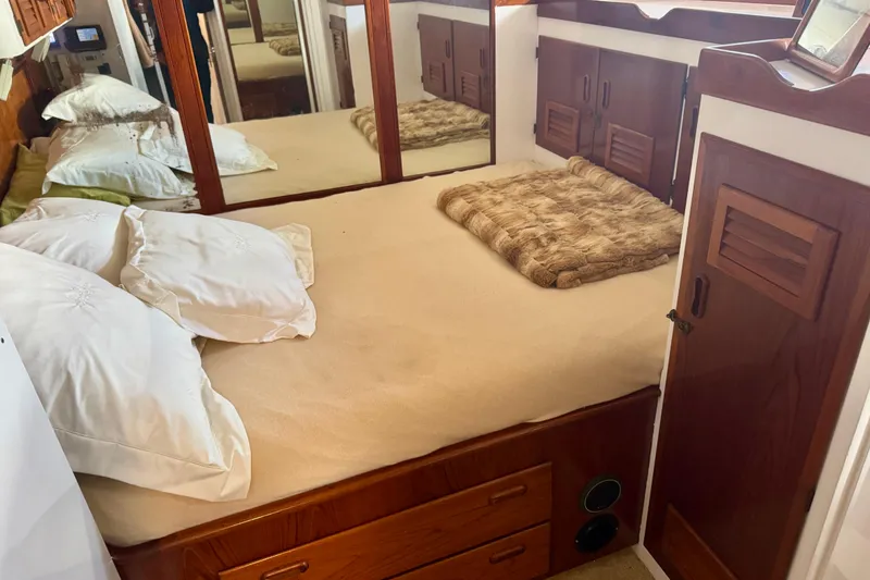 Slide: The Image of Cozy bedroom in a 1958 Blanchard Pilothouse boat with wooden cabinetry and mirrored walls. - 25