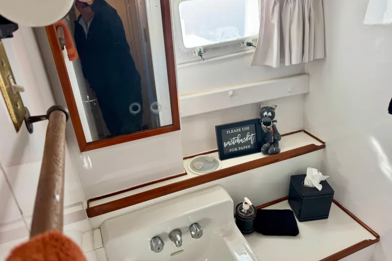 Slide: The Image of 1958 Blanchard Pilothouse bathroom with mirror, sink, and decorative items. - 26