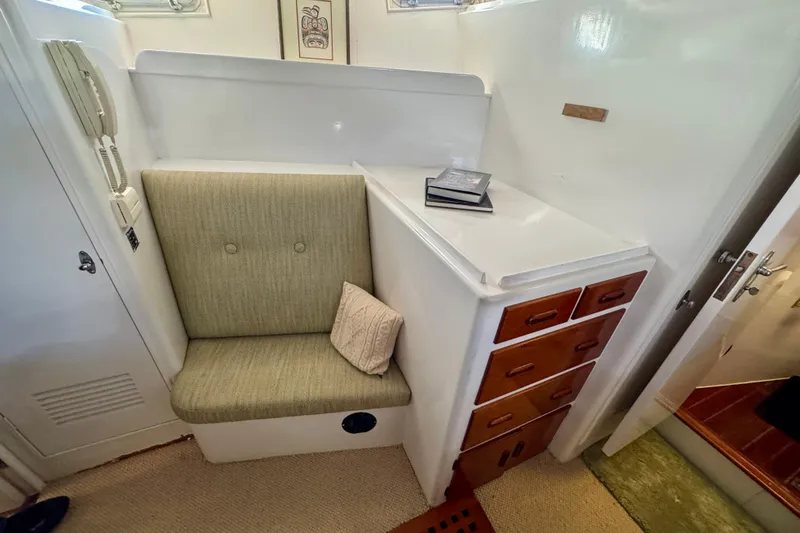 Slide: The Image of 1958 Blanchard Pilothouse interior with cushioned seat, wooden drawers, and nautical decor. - 31