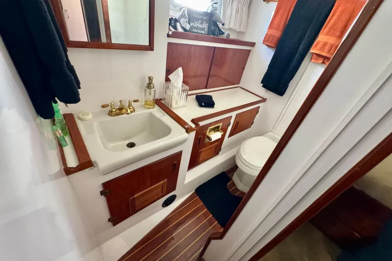 Slide: The Image of 1958 Blanchard Pilothouse bathroom with wooden cabinetry, sink, and toilet. - 35