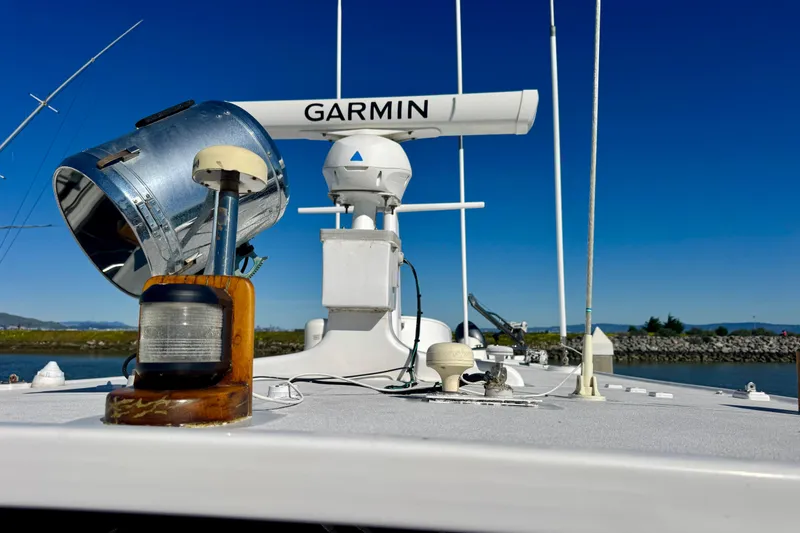 Slide: The Image of 1958 Blanchard Pilothouse boat deck with Garmin radar and spotlight under clear blue sky. - 47