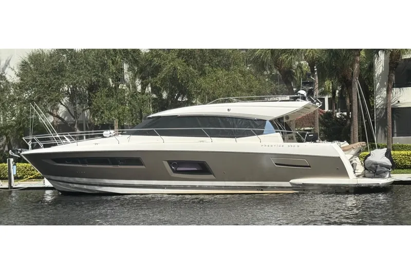 Slide: The Image of 2013 Prestige 550 S yacht docked by lush greenery. - 57