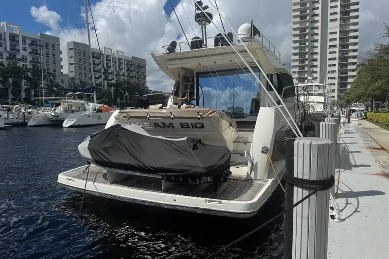 Slide: The Image of Luxury 2013 Prestige 550 S yacht docked at marina with cityscape backdrop. - 59