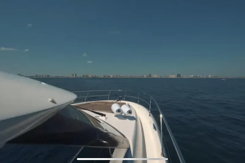 Slide: The Image of Prestige 550 S yacht cruising on open water, city skyline in background, 2013 model. - 9