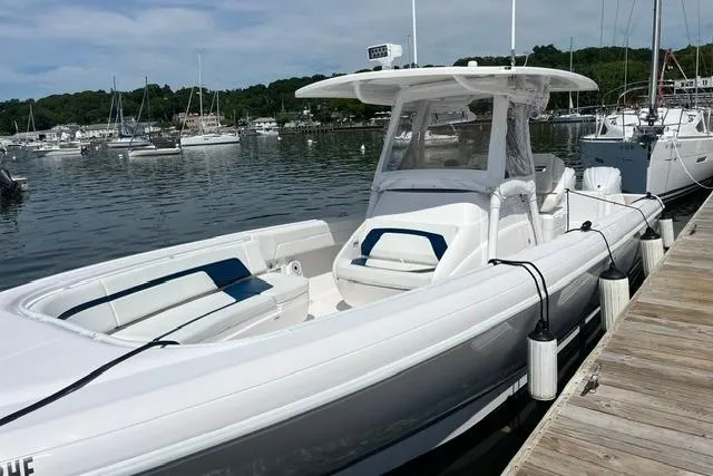 Slide: The Image of 2022 Intrepid 327 Center Console boat docked at a marina, surrounded by water and other boats. - 6