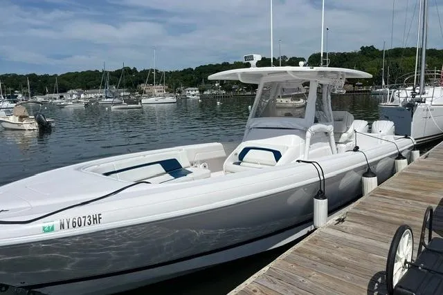 Slide: The Image of 2022 Intrepid 327 Center Console boat docked at a marina, surrounded by other vessels. - 7