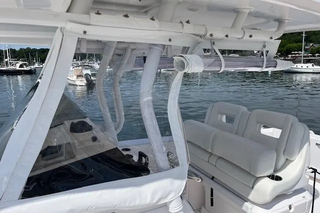 Slide: The Image of 2022 Intrepid 327 Center Console boat with sleek design, docked in a marina. - 9