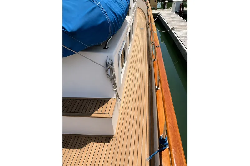 Slide: The Image of 1989 Grand Banks 42 Classic yacht deck with teak wood and blue cover. - 10