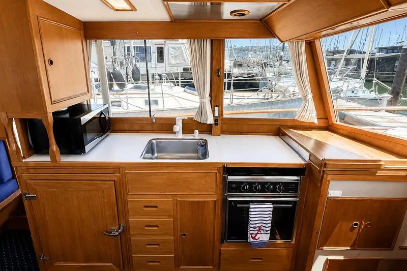Slide: The Image of Galley of 1989 Grand Banks 42 Classic yacht with wood cabinetry and marina view. - 28