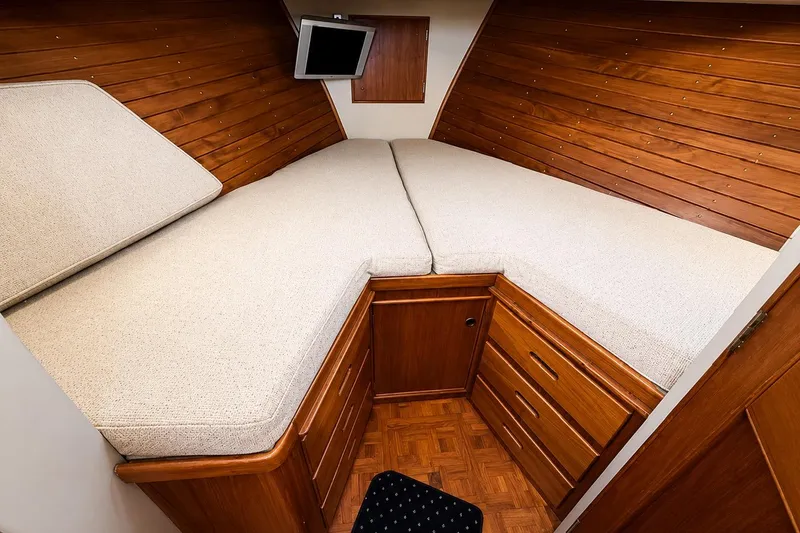 Slide: The Image of Cozy cabin interior of 1989 Grand Banks 42 Classic yacht with wooden paneling and bedding. - 34