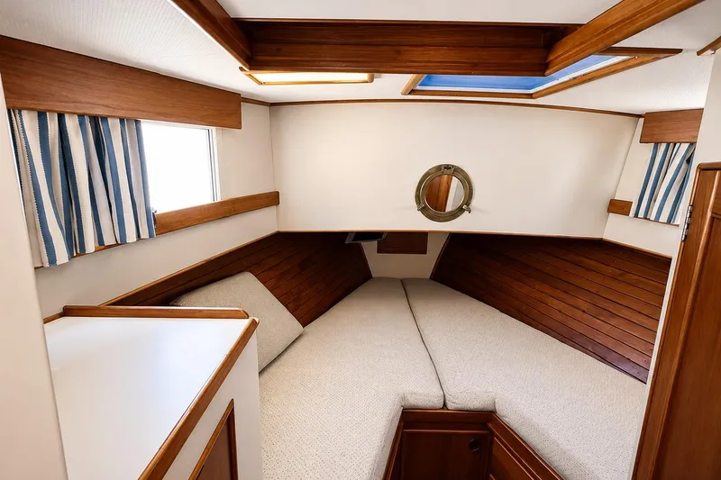 Slide: The Image of 1989 Grand Banks 42 Classic cabin interior with wood paneling and striped curtains. - 35