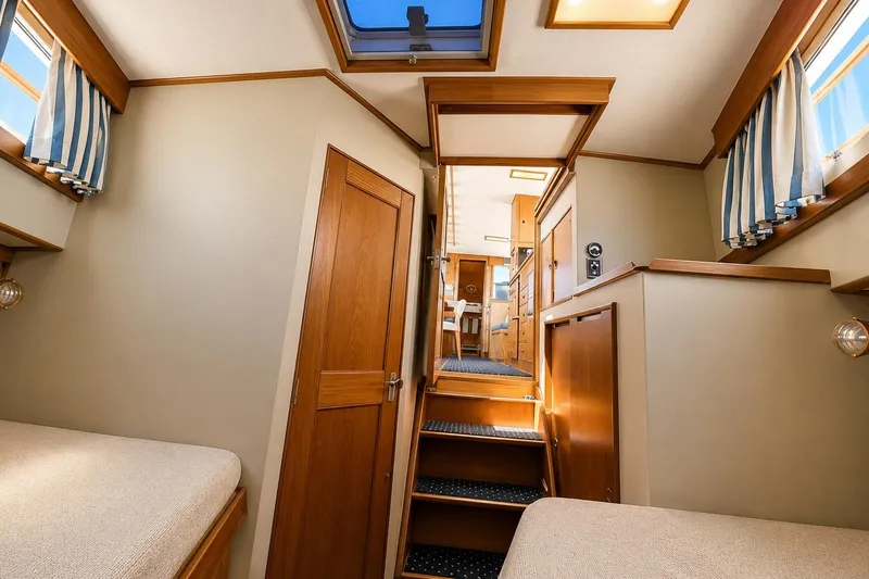 Slide: The Image of Interior of 1989 Grand Banks 42 Classic yacht with wooden finishes and striped curtains. - 36