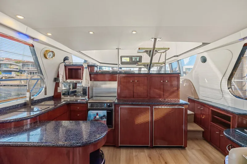 Slide: The Image of Luxurious interior of 1999 Carver 53 Voyager yacht with modern kitchen and wood finishes. - 8