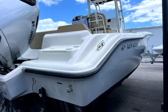 Slide: The Image of 2020 Key West 239 FS boat with Honda engine, docked under a blue sky. - 2