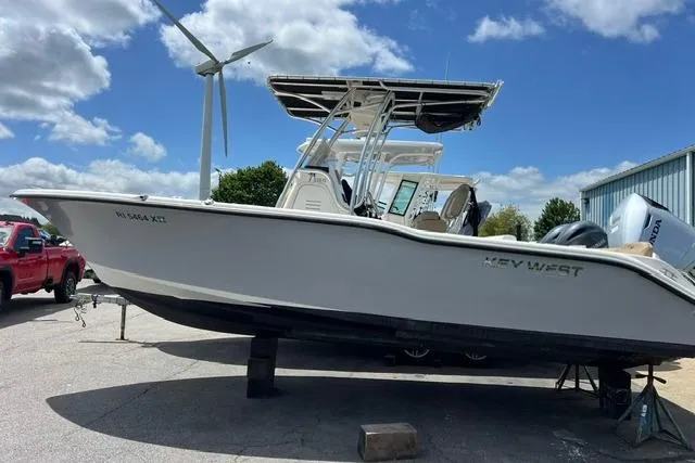 Slide: The Image of 2020 Key West 239 FS boat on display, clear sky background, parked near a red truck. - 6