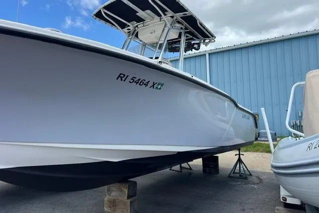 Slide: The Image of 2020 Key West 239 FS boat on stands, near blue building, clear sky. - 7