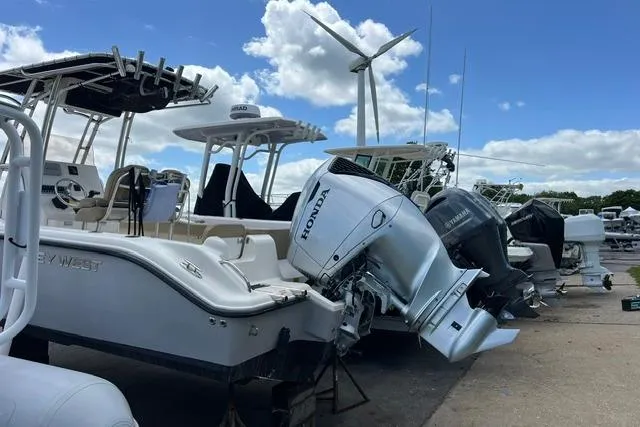 Slide: The Image of Boats docked with outboard motors, including a 2020 Key West 239 FS, under a clear sky. - 8