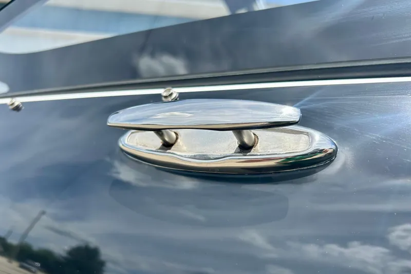 Slide: The Image of Chrome cleat on 2021 Scarab 195 ID boat, reflecting sky and clouds. - 14