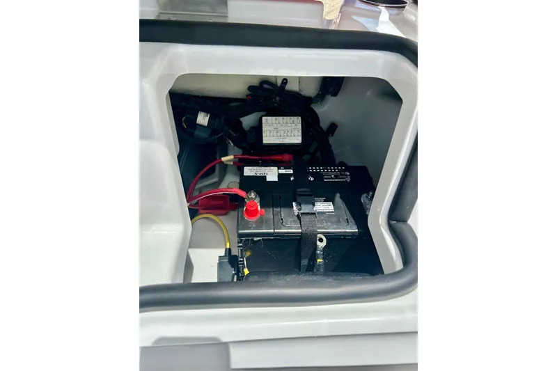 Slide: The Image of Battery compartment of a 2021 Scarab 195 ID boat, featuring wiring and connections. - 36