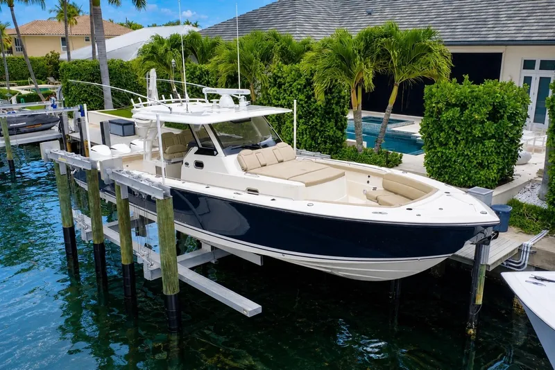 The Image of 2018 Pursuit S 408 Sport boat docked by a luxurious waterfront home. - 0