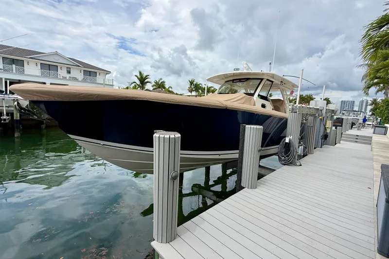 Slide: The Image of 2018 Pursuit S 408 Sport boat docked at marina with covered deck. - 10