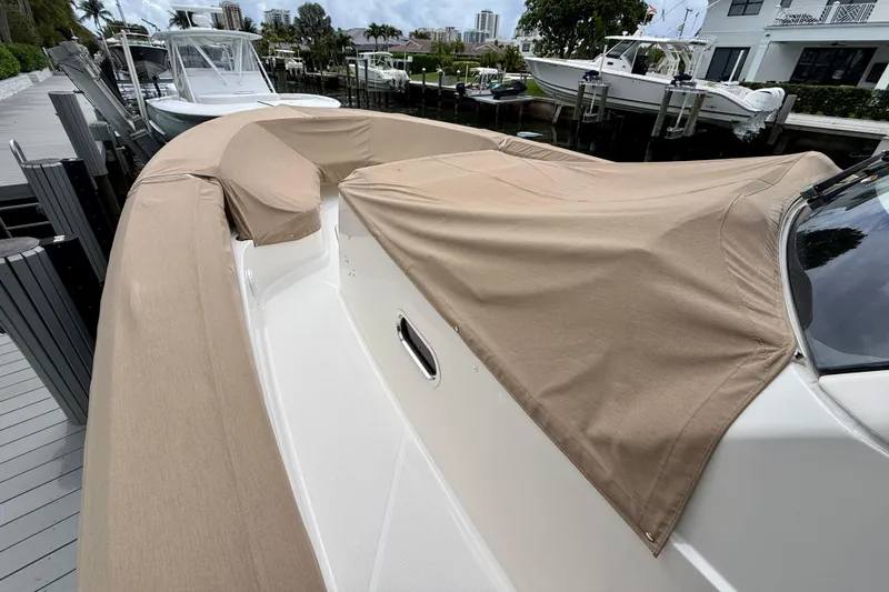 Slide: The Image of 2018 Pursuit S 408 Sport boat with protective cover docked at marina. - 17
