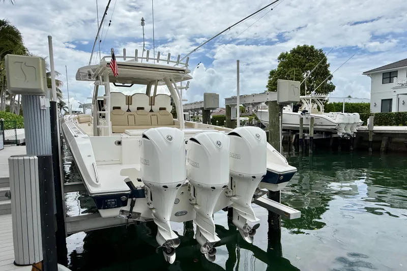 Slide: The Image of 2018 Pursuit S 408 Sport boat docked with triple outboard engines. - 20
